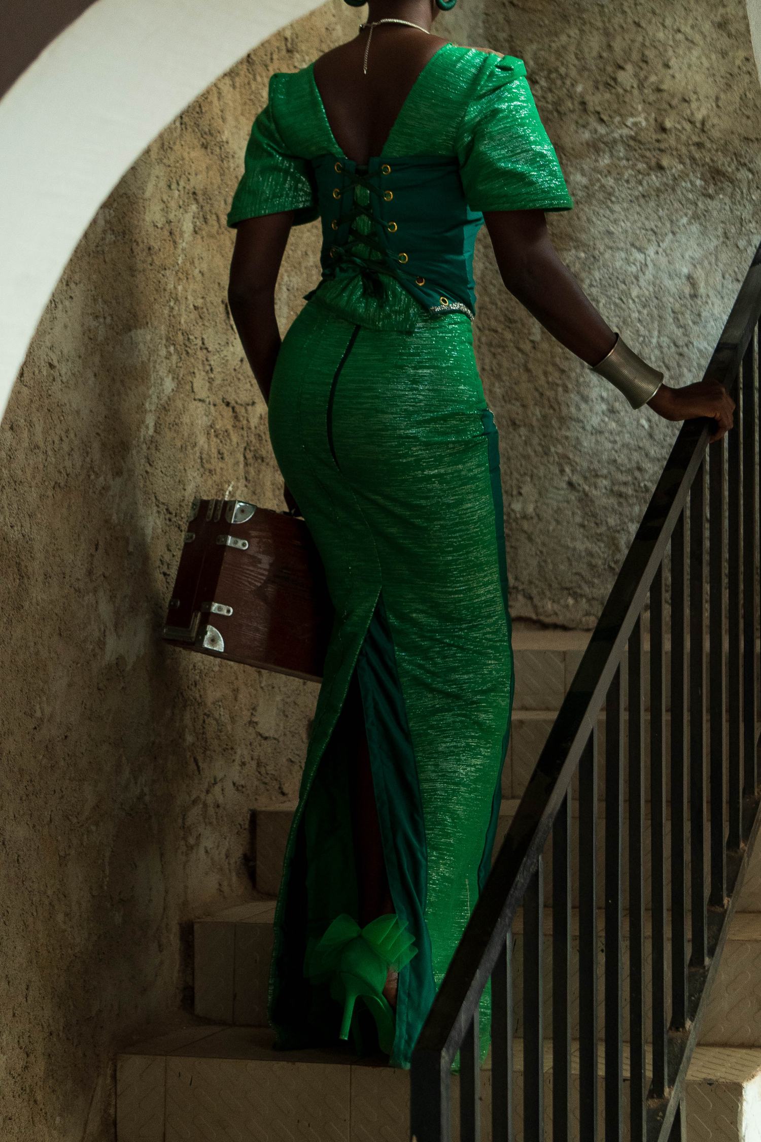 Femme en robe verte dans un escalier
